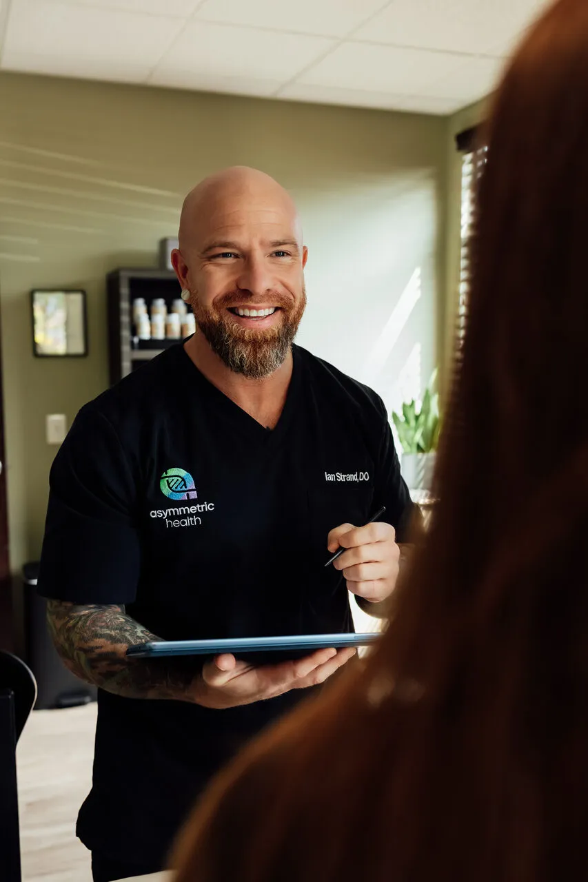 Dr. Ian Strand reviewing a patient's case during a 60 to 90 minute consultation at Asymmetric Health